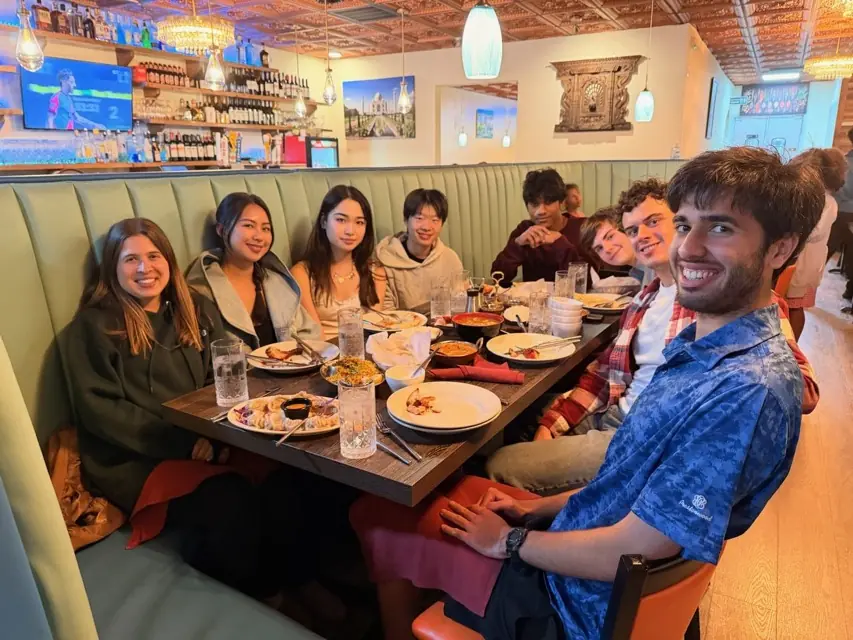 Members seated around a long restaurant table with plates of food