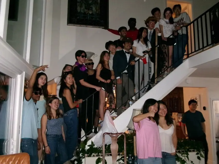 Members gathered on and around a staircase in a house