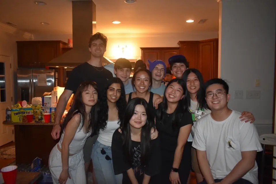 About a dozen members crowded together in a kitchen